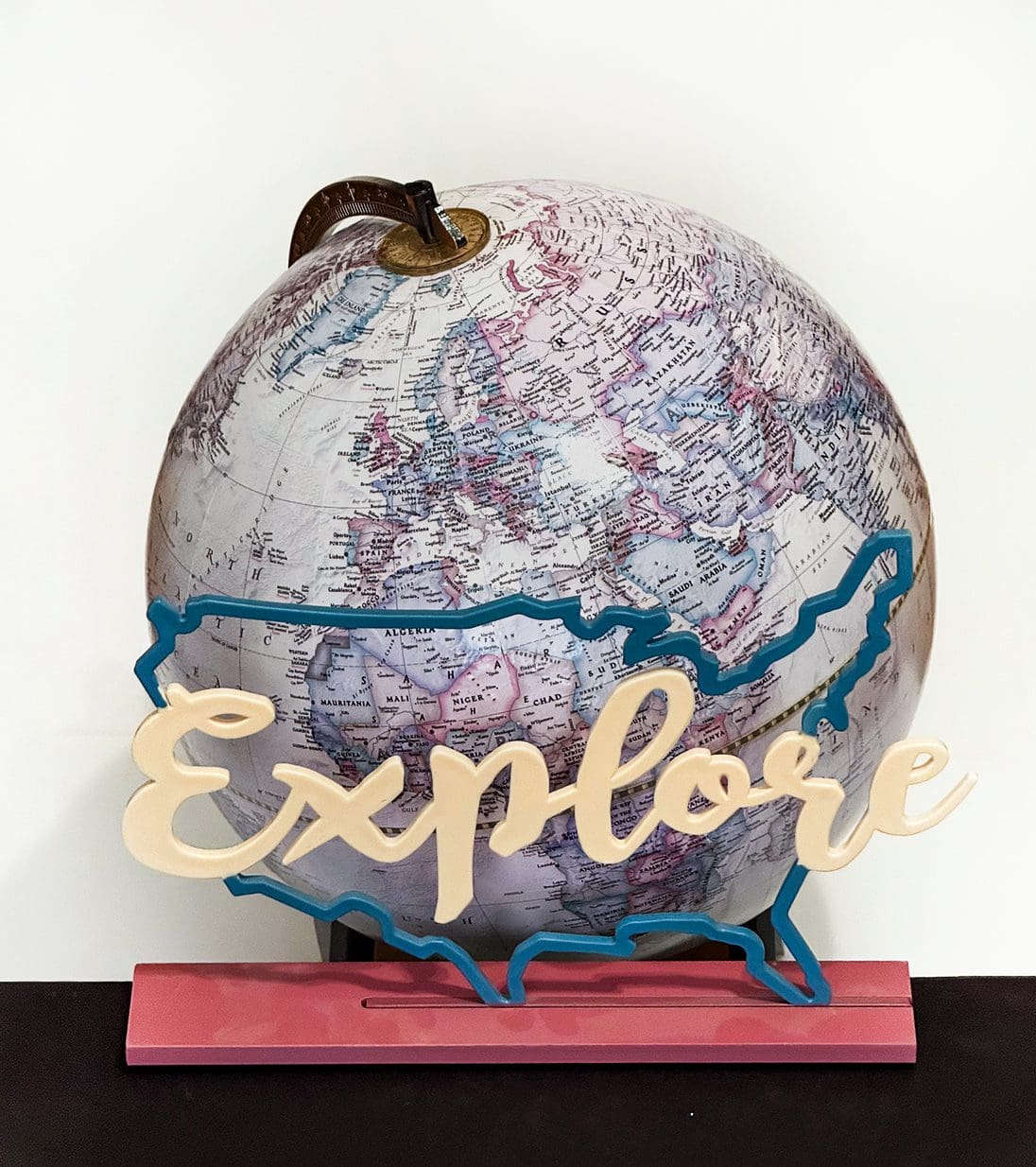 Decorative globe with a wooden "Explore" sign in front.