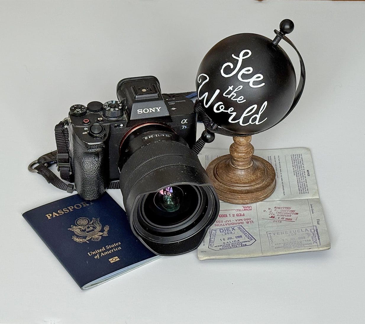 Travel essentials including camera, passport, globe, and map.